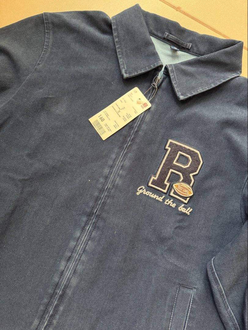 Uniqlo Kids Denim Jacket with 'R' Patch (Category: Babies & Kids Fashion) located in Makati City. Submitted by etherealuxe.ph (Listing ID 1464627048, Image 1). Description: Brand New Uniqlo Kids Jersey Work Jacket Dark Denim in person. Photo color may be different due to lighting. - Blue denim jacket for kids - Features a cool 'R' patch with a football and 'Ground the ball' text - Zip-up front closure - Two side pockets - Perfect for casual wear 