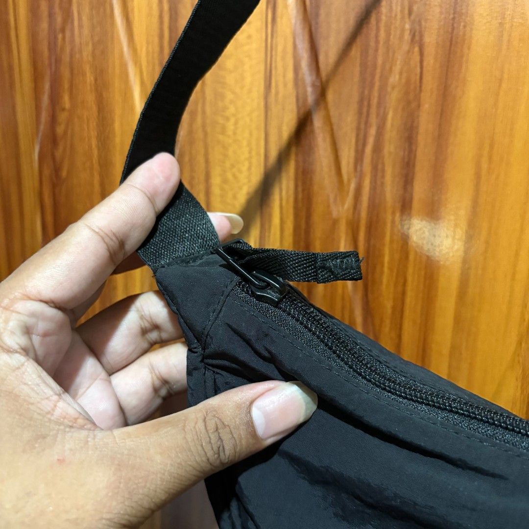 Uniqlo Round Mini Shoulder Bag Black (Category: Shoulder Bags) located in Carmen. Submitted by ar_thrift00 (Listing ID 1464715887, Image 3). Description: - Brand: Uniqlo - Color: Classic Black - Material: Soft nylon shell with polyester filling and lining - Closure: Smooth zipper with dual pull tabs - Storage: Includes an inside zip pocket for small items - Strap: Adjustable strap with sturdy buckle - Style: Practical everyday crossbody bag with 