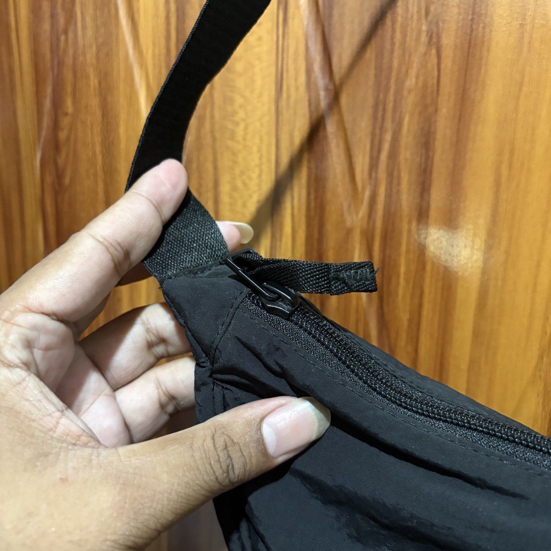 Uniqlo Round Mini Shoulder Bag Black (Category: Cross-body Bags) located in Carmen. Submitted by rr_thrifts (Listing ID 1464719568, Image 3). Description: - Brand: Uniqlo - Style: Crescent shoulder bag - Color: Classic black - Material: Durable nylon fabric with polyester lining - Closure: Top zip with matching fabric pull tab - Strap: Adjustable with plastic hardware - Condition: Clean inside and out, smoke-free - Capacity: Roomy shape fits dail