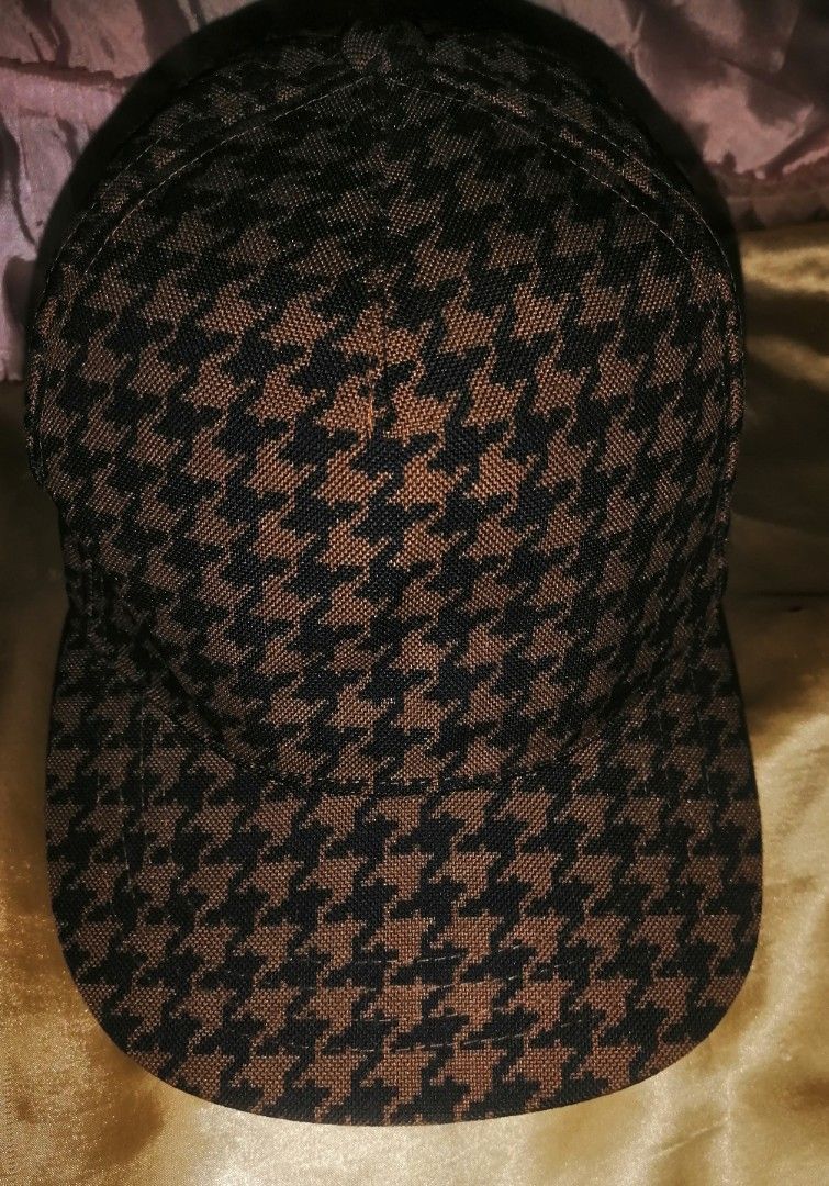 Uniqlo x i am OTHER Houndstooth Cap (Category: Caps & Hats) located in Quezon City. Submitted by rolenalma (Listing ID 1464707600, Image 1). Description: - Brand: Uniqlo x Pharrell Williams (i am OTHER collaboration) - Design: Brown and black houndstooth pattern on crown and brim - Details: Multicolored embroidered lettering on the back - Fit: Adjustable nylon strap with plastic buckle closure - Condition: Excellent, clean black interior lining w