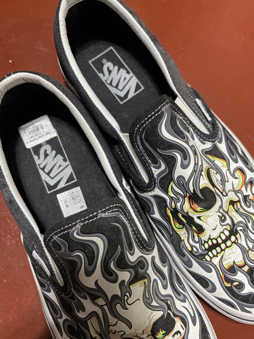 Vans Classic Slip-On Skull Flame Print (Category: Sneakers) located in Manila. Submitted by finderskeepersmnl_092026 (Listing ID 1464710278, Image 2). Description: - Brand: Vans - Style: Classic Slip-On with elastic side goars - Design: Bold skull and flame graphic in black, white, orange, and green - Soles: Signature waffle rubber outsoles - Perfect for daily wear and making a street-style statement.