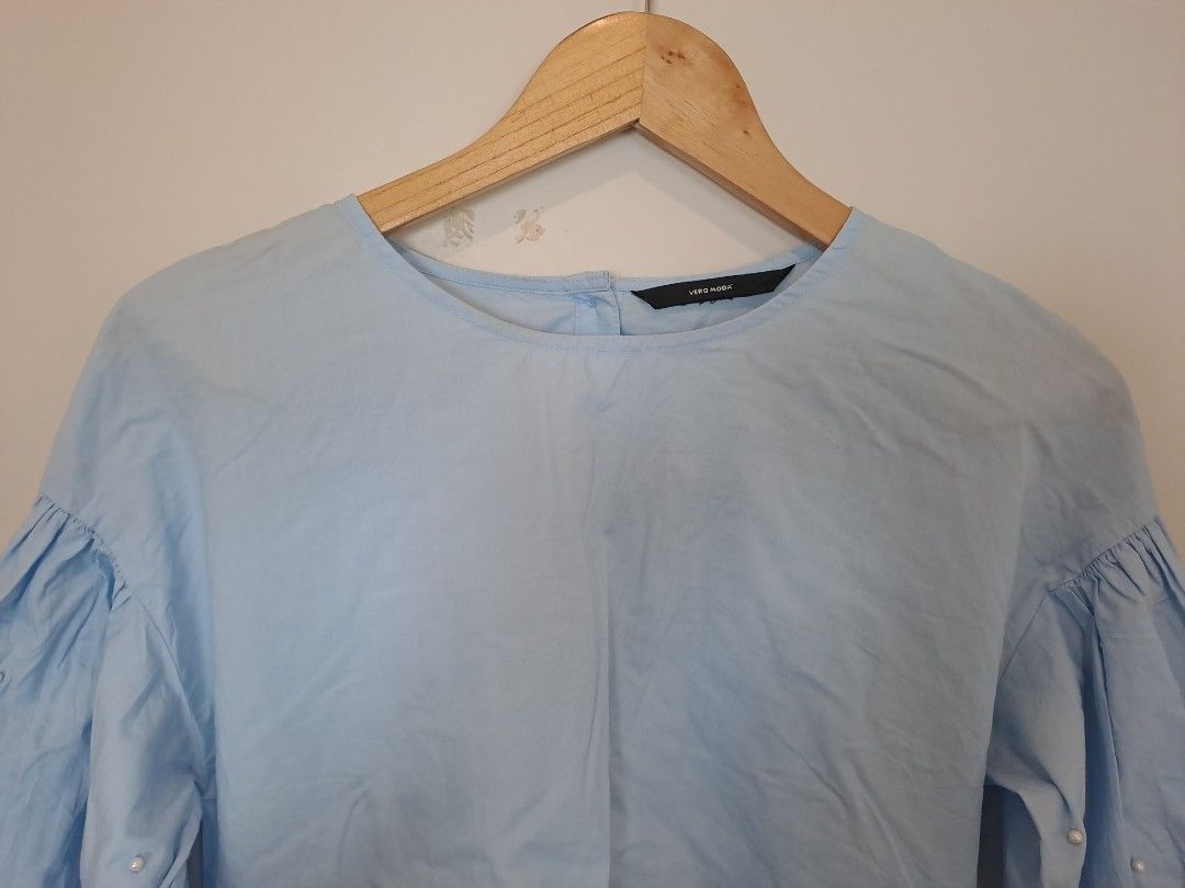 Vero Moda blouses (Category: Blouses) located in Manila. Submitted by joanbalde39643 (Listing ID 1464673364, Image 2). Description: This is Vero Moda a light blue cotton poplin blouse featuring a crew neckline, side-tie accent straps, and 3/4-length voluminous balloon sleeves accented with small faux pearl embellishments. It is designed with a small keyhole button closure at the back of the neck..