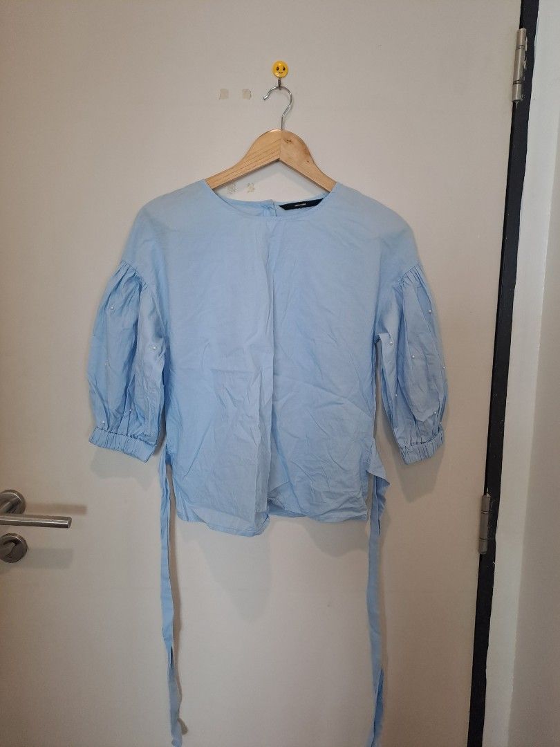 Vero Moda blouses (Category: Blouses) located in Manila. Submitted by joanbalde39643 (Listing ID 1464673364, Image 1). Description: This is Vero Moda a light blue cotton poplin blouse featuring a crew neckline, side-tie accent straps, and 3/4-length voluminous balloon sleeves accented with small faux pearl embellishments. It is designed with a small keyhole button closure at the back of the neck..