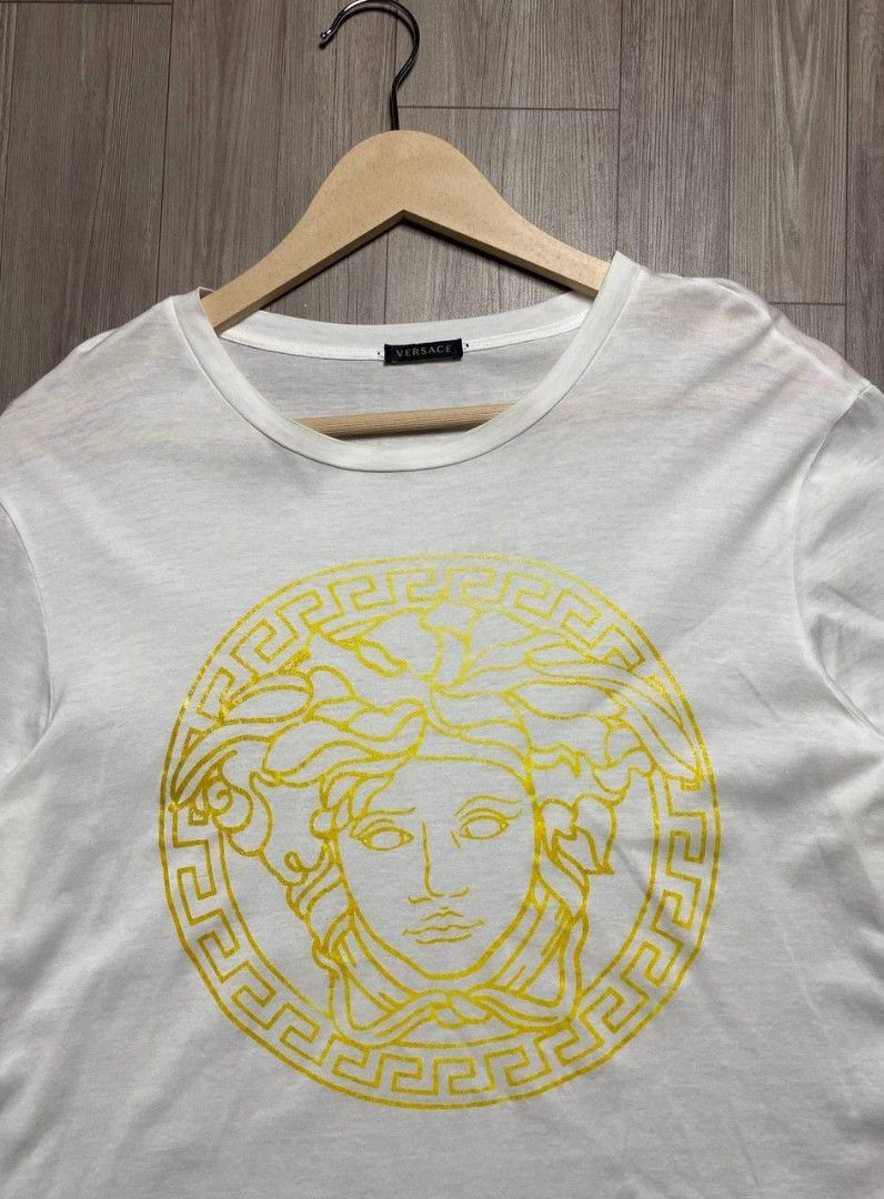 VERSACE MEDUSA HEAD GLITTER/FOIL GRAPHTEE - WHITE (Category: Shirts) located in Manila. Submitted by ztfirtfritz (Listing ID 1464704602, Image 2). Description: VERSACE MEDUSA HEAD GLITTER/FOIL GRAPHTEE - WHITE LEGIT SIZE 40 ON TAG WOMEN'S SMALL (IT40) MEASUREMENTS" SHOULDER: 18 SLEEVE: 8 PIT: 20 LENGTH: 27 MEDIUM TO LARGE VERY GOOD FLAWS: MINOR FADE ON PRINTS STILL PRESENTABLE 650 + SF.