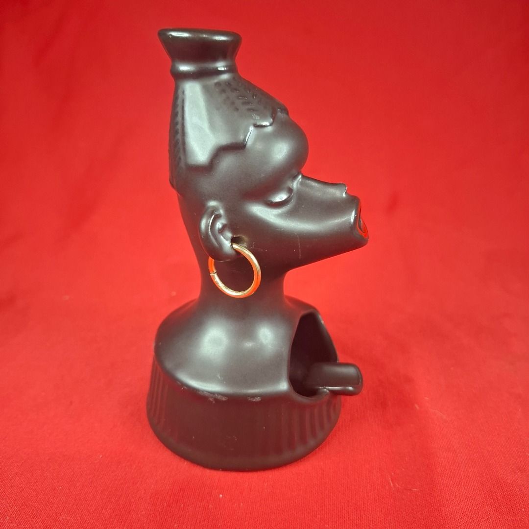 Vintage Black Ceramic Figural Head Ashtray (Category: Vintage Collectibles) located in Mandaluyong City. Submitted by edward123_andren (Listing ID 1464710170, Image 2). Description: - Mid-century novelty black ceramic ashtray - Shaped like a stylish woman with a high bun and gold hoop earrings - Bright red painted open mouth securely holds cigarettes - Features a built-in rest slot and grooved sides on the base - Stands approximately 13 cm tall -