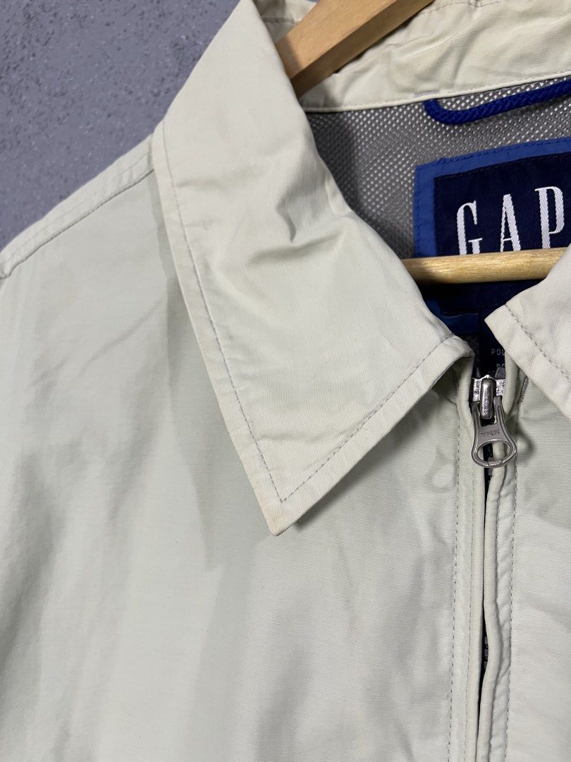 Vintage Gap Harrington Zip Up Jacket 2XL (Category: Coats, Jackets and Outerwear) located in Famy. Submitted by basicthrifted (Listing ID 1464701988, Image 3). Description: - Brand: Gap - Style: Zip-up jacket with classic collar - Color: Cream - Size: 2XL (Tag measurements: 31" x 27.5") - Features: Front pockets, button cuffs, and mesh inner lining - Condition: Pre-loved with minor stains on the collar and fabric (please check photos closely).