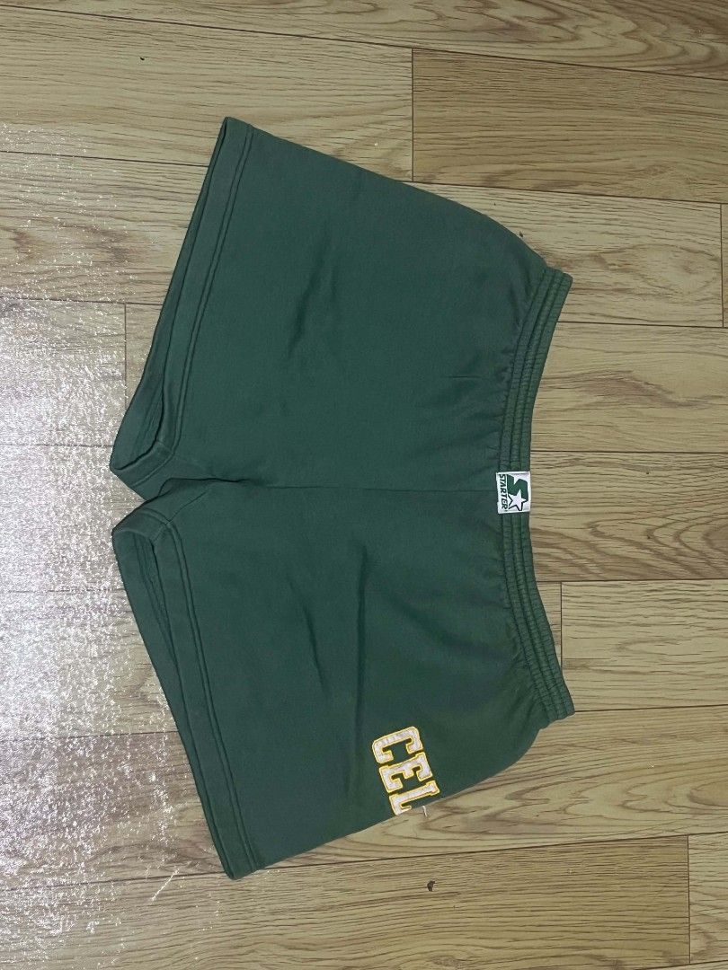 Vintage Starter Athletic Shorts "CELTICS" (Category: Shorts) located in Aguinaldo. Submitted by true.north_archive (Listing ID 1464677691, Image 1). Description: - Brand: Starter - Color: Green - Size: Medium - Features: 'CELTICS' on left leg, elastic waistband with drawstring, back right pocket - Material: 65% Polyester, 35% Cotton.