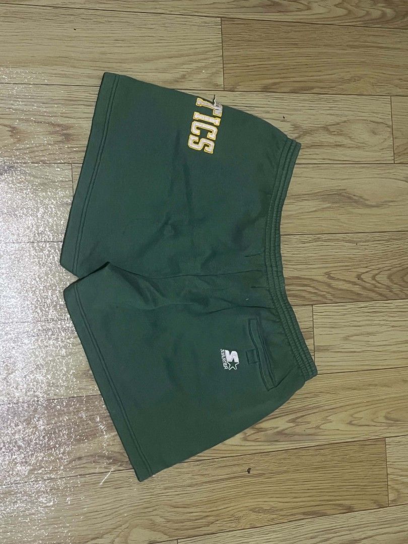 Vintage Starter Athletic Shorts "CELTICS" (Category: Shorts) located in Aguinaldo. Submitted by true.north_archive (Listing ID 1464677691, Image 2). Description: - Brand: Starter - Color: Green - Size: Medium - Features: 'CELTICS' on left leg, elastic waistband with drawstring, back right pocket - Material: 65% Polyester, 35% Cotton.