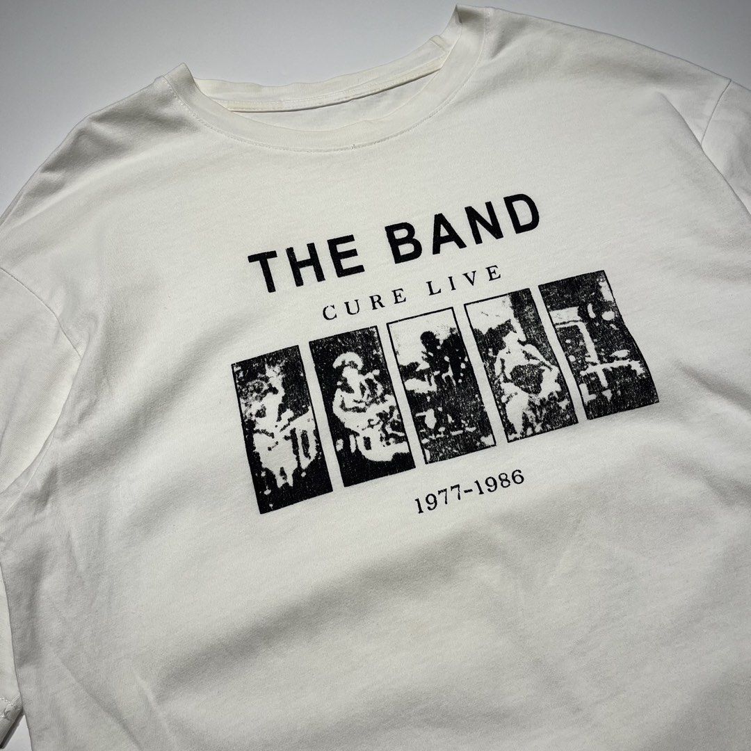 Vintage The Cure Band Tee (Category: Tshirts & Polo Shirts ) located in Balanga. Submitted by goodiegarments (Listing ID 1464583766, Image 2). Description: Vintage The Cure Archival Band Tee An absolute essential for post-punk and new wave collectors. This graphic t-shirt pays homage to The Cure's legendary first decade, featuring an iconic, distressed photo-strip graphic of Robert Smith and the band. Beautifully faded and worn-in to achieve the 