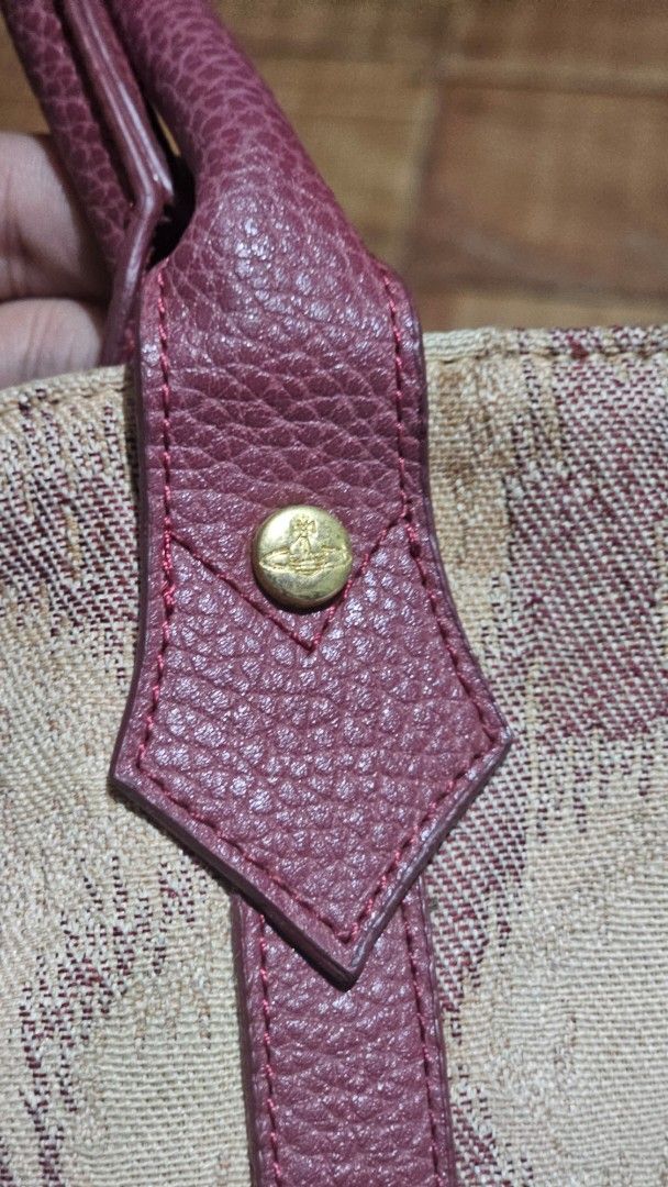 Vivienne Westwood Patterned Tote Bag (Category: Luxury Bags & Wallets) located in Kibawe. Submitted by Thrift_ni_Babac (Listing ID 1464690661, Image 2). Description: - Authentic Vivienne Westwood tote bag - Beige and dark red patterned exterior with maroon leather shoulder straps - Signature gold-tone orb hardware studs and front orb logo plaque - Satin interior lining with branded pattern - Includes a zipper pocket, slip pocket, and magnetic sna