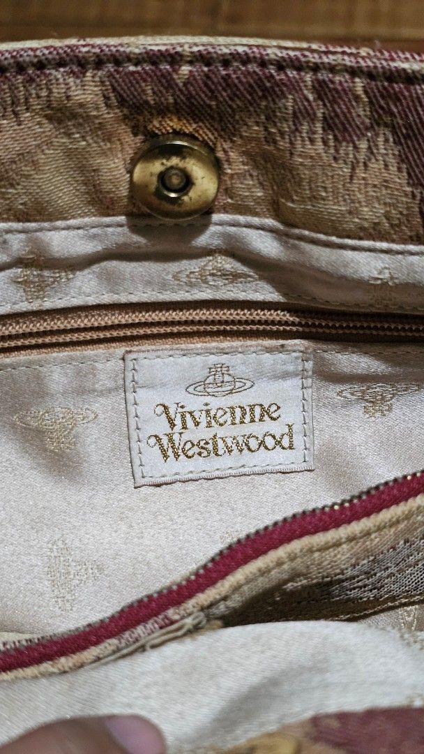 Vivienne Westwood Patterned Tote Bag (Category: Luxury Bags & Wallets) located in Kibawe. Submitted by Thrift_ni_Babac (Listing ID 1464690661, Image 3). Description: - Authentic Vivienne Westwood tote bag - Beige and dark red patterned exterior with maroon leather shoulder straps - Signature gold-tone orb hardware studs and front orb logo plaque - Satin interior lining with branded pattern - Includes a zipper pocket, slip pocket, and magnetic sna