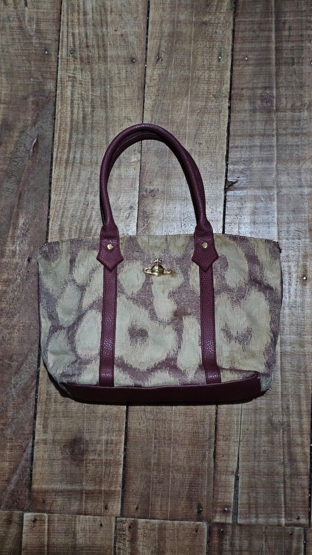Vivienne Westwood Patterned Tote Bag (Category: Luxury Bags & Wallets) located in Kibawe. Submitted by Thrift_ni_Babac (Listing ID 1464690661, Image 1). Description: - Authentic Vivienne Westwood tote bag - Beige and dark red patterned exterior with maroon leather shoulder straps - Signature gold-tone orb hardware studs and front orb logo plaque - Satin interior lining with branded pattern - Includes a zipper pocket, slip pocket, and magnetic sna