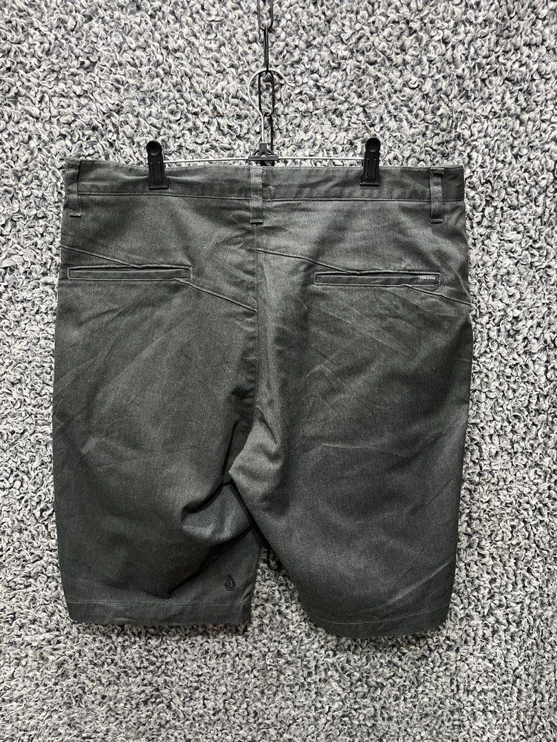 Volcom men's shorts | Size 34 (Category: Shorts) located in General Trias. Submitted by zrchustle.604 (Listing ID 1464626396, Image 3). Description: Volcom men's shorts in a dark charcoal grey colorway. They feature Volcom's signature asymmetrical back yoke stitching pattern across the upper rear panel, welted rear pockets, a classic flat-front construction, and the signature embroidered Volcom stone logo located on the lower back left leg..