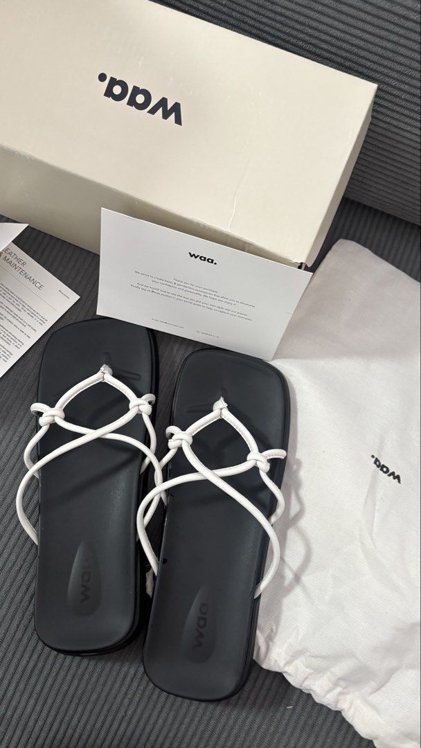 WAA. Black Thong Sandals with White Straps (Category: Flats & Sandals) located in Manila. Submitted by cosmichorse.2280f0 (Listing ID 1464602653, Image 1). Description: - WAA black thong sandals - White criss-cross strap detail - Comes with original box, dust bag, and care card - Recently purchased - Selling because it's not my style - Please check photos for detailed condition -Brand newwwww!!.