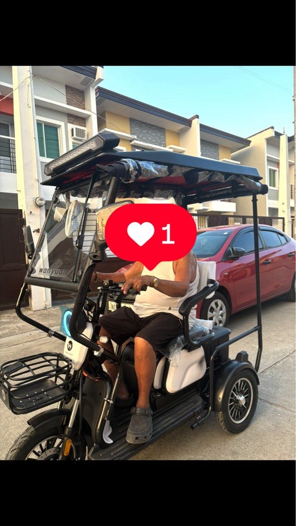 Wanyuan Electric Tricycle With Canopy And Storage (Category: Motorbikes for Sale) located in Manila. Submitted by jobithings (Listing ID 1464737921, Image 1). Description: Wanyuan electric tricycle with a full black roof canopy and front windshield. Includes handlebars, front storage basket, cushioned seating with backrest, and overhead fan. Rear storage box fitted behind the seat. Black and white frame design with LED light bar on top roof edge.