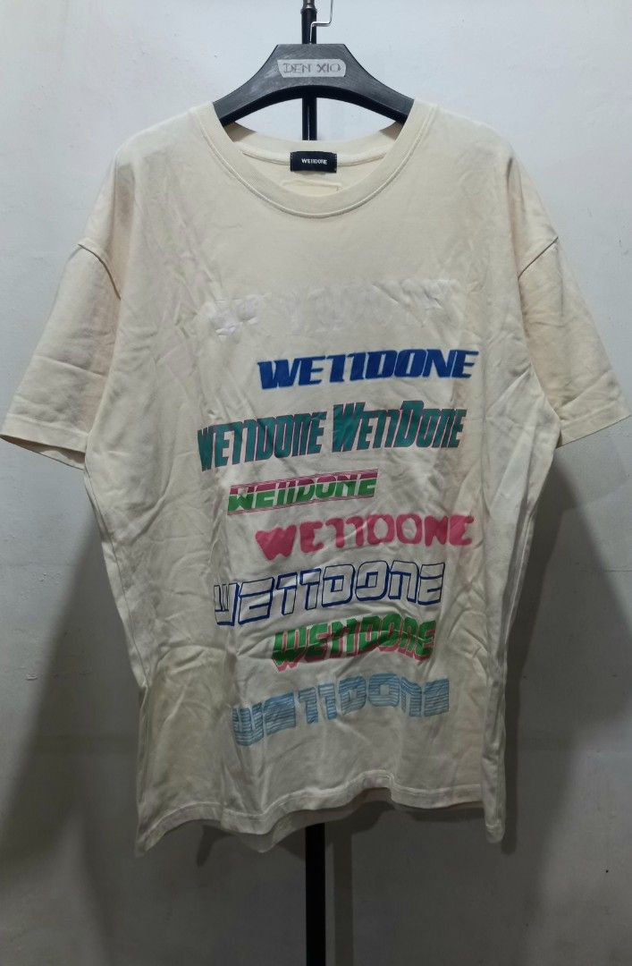 WE11DONE T-Shirt Cream Multi-Logo Print (Category: Tshirts & Polo Shirts ) located in Tarlac. Submitted by den420 (Listing ID 1464656975, Image 1). Description: - Brand: WE11DONE - Color: Cream - Design: Graphic print with multiple "WE11DONE" logos in various colors - Neckline: Classic crew neck - Sleeves: Short sleeves - Material: Comfortable fabric - Occasion: Perfect for casual wear.