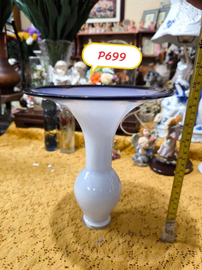 White and Blue Glass Vase (Category: Vases & Decorative Bowls) located in Quezon City. Submitted by louidanny3 (Listing ID 1464613883, Image 1). Description: - White glass vase with a striking blue rim - Unique flared shape adds a touch of elegance - Ideal for showcasing your favorite flowers - Stands approximately 8 inches tall - A beautiful addition to any home decor.