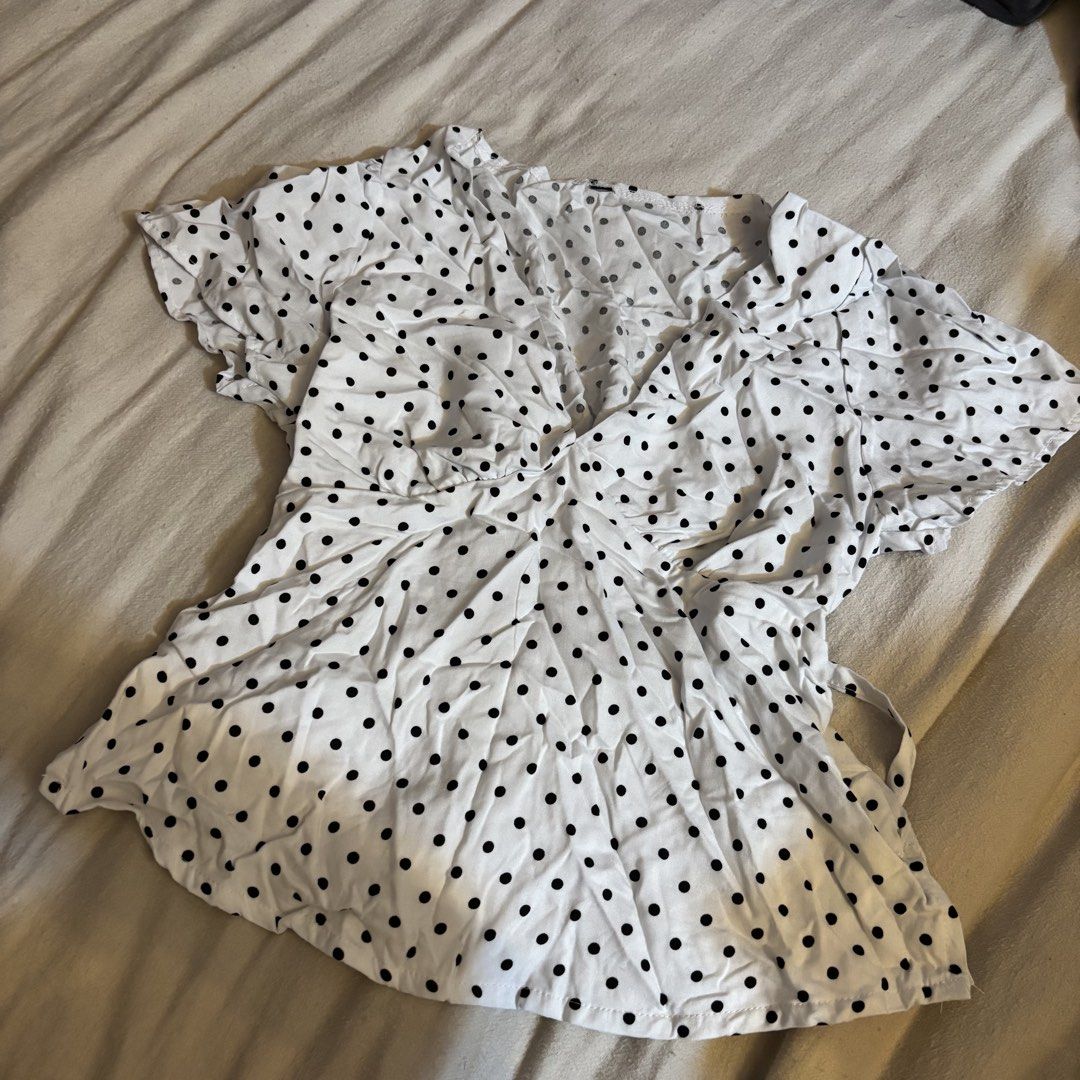 White Black Polka Dot V-Neck Wrap Top (Category: Blouses) located in Cainta. Submitted by kairus.luckyfind (Listing ID 1464656826, Image 1). Description: - Cute white top with black polka dots - V-neck design - Wrap-around style - Short, fluttery sleeves - Ties at the side - Versatile for casual or dressy occasions - Pairs well with jeans or skirts.