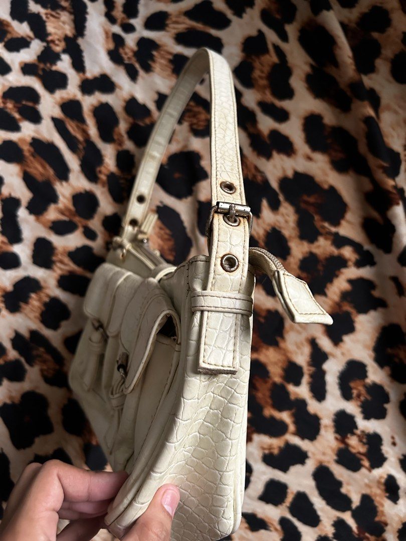 White Croc Embossed Shoulder Bag with Buckle Details (Category: Shoulder Bags) located in Los Banos. Submitted by samsukehiro (Listing ID 1464579639, Image 3). Description: - White shoulder bag with stylish croc-embossed texture. - Features two front pockets with secure buckle closures. - Zip top closure for main compartment. - Adjustable shoulder strap with buckle details. - Classic Y2K aesthetic, perfect for vintage lovers. - Please note: Minor