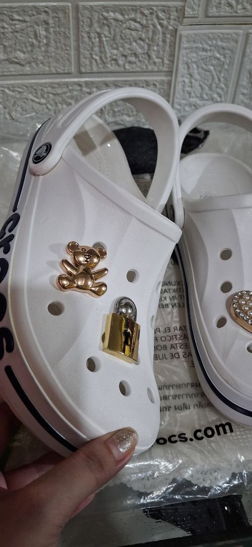 White Crocs with Teddy Bear, Lock, and Heart Charms (Category: Slippers and slides) located in Manila. Submitted by katkween23 (Listing ID 1464587899, Image 2). Description: - White Crocs with adorable charm decorations - Includes: Teddy bear charm, lock charm, heart charm with rhinestones - Fun and stylish design to express your personality - Easy slip-on, slip-off style - Ideal for everyday casual wear.