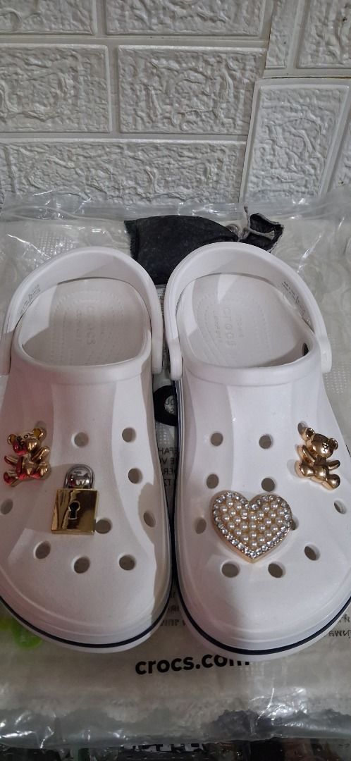 White Crocs with Teddy Bear, Lock, and Heart Charms (Category: Slippers and slides) located in Manila. Submitted by katkween23 (Listing ID 1464587899, Image 3). Description: - White Crocs with adorable charm decorations - Includes: Teddy bear charm, lock charm, heart charm with rhinestones - Fun and stylish design to express your personality - Easy slip-on, slip-off style - Ideal for everyday casual wear.