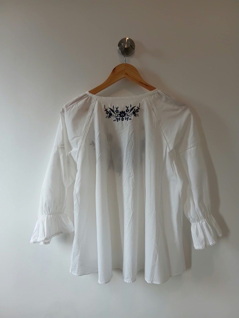 White Embroidered Blouse with Tassel Tie (Category: Blouses) located in Manila. Submitted by wisecat.4a7eea (Listing ID 1464635314, Image 2). Description: - Elegant white long-sleeved blouse - Beautiful navy blue floral embroidery on the front - Unique tassel tie detail at the neckline - Ruffled hem on the sleeves - Fits size Medium to Large (M-L) - Ideal for casual wear and everyday style.