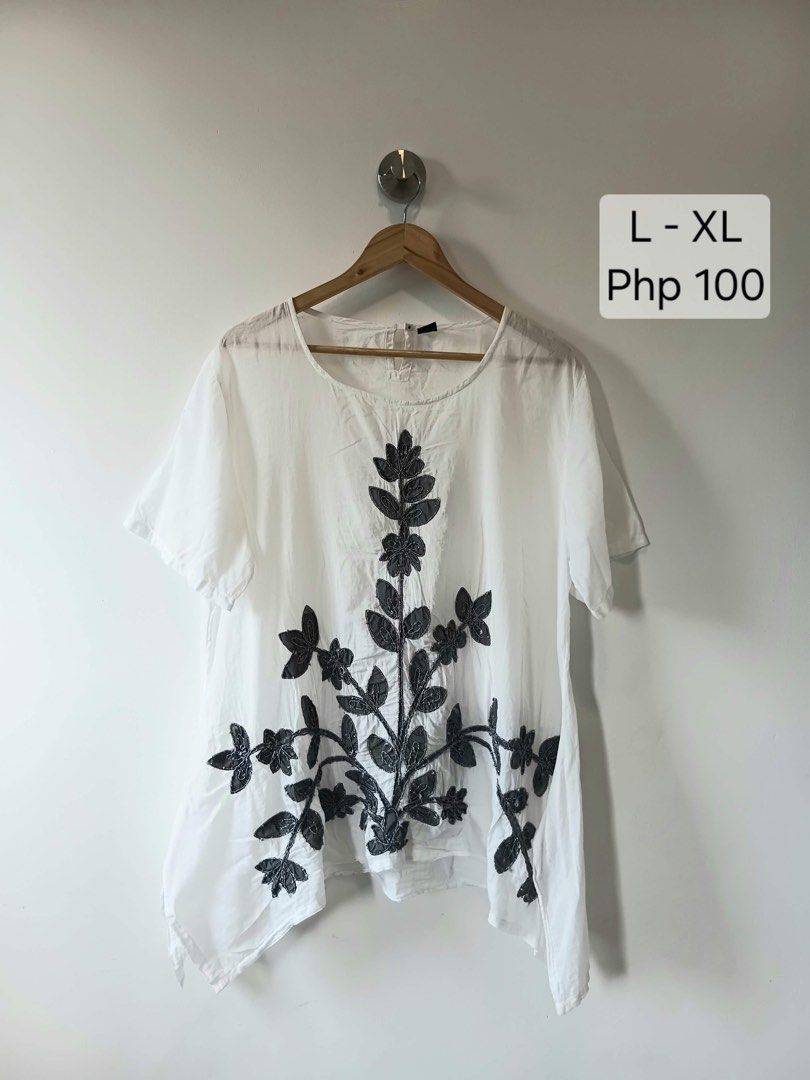 White Embroidered Top L-XL (Category: Blouses) located in Manila. Submitted by wisecat.4a7eea (Listing ID 1464606411, Image 1). Description: - Chic white top with elegant dark grey floral embroidery on the front. - Features short sleeves and a classic round neckline. - Designed for a relaxed, loose fit with a stylish asymmetrical hem. - Ideal for effortless casual wear. - Size L-XL..