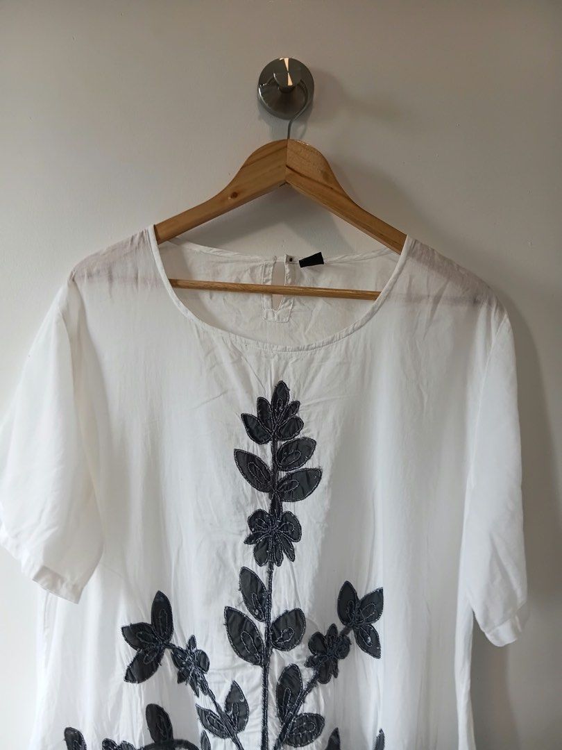 White Embroidered Top L-XL (Category: Blouses) located in Manila. Submitted by wisecat.4a7eea (Listing ID 1464606411, Image 3). Description: - Chic white top with elegant dark grey floral embroidery on the front. - Features short sleeves and a classic round neckline. - Designed for a relaxed, loose fit with a stylish asymmetrical hem. - Ideal for effortless casual wear. - Size L-XL..