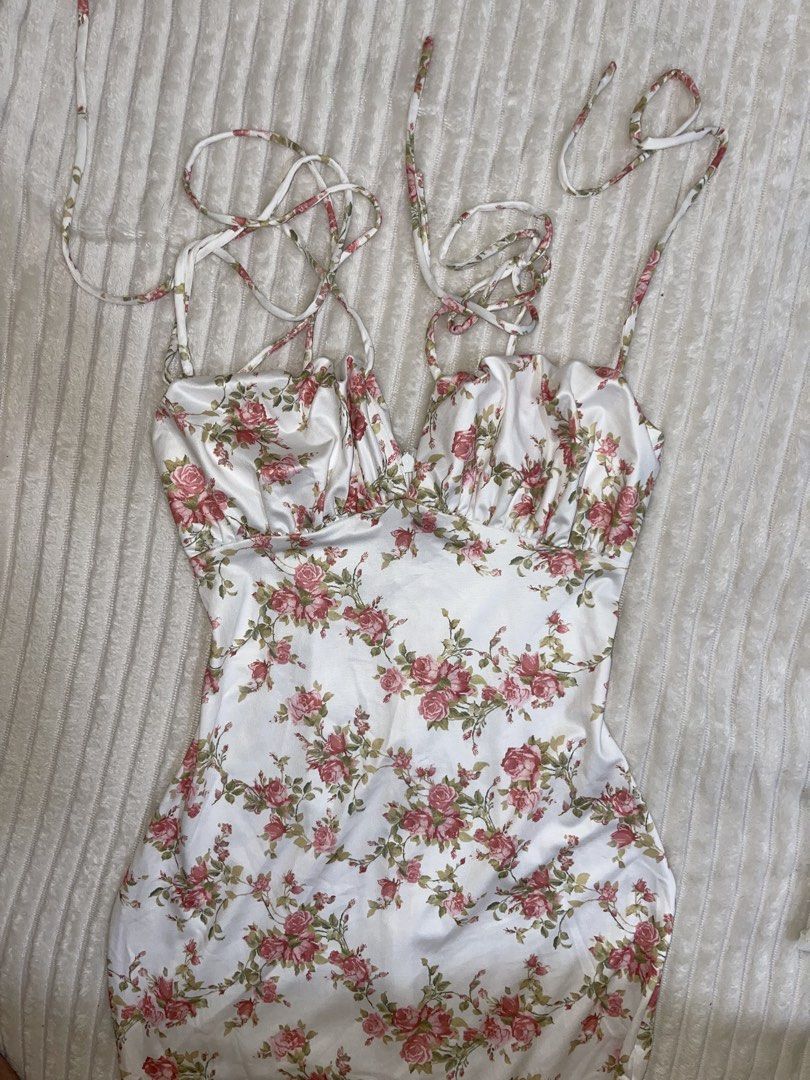 White Floral Satin Dress (Category: Dresses) located in Manila. Submitted by rare.yurichi (Listing ID 1464739018, Image 2). Description: Elegant silky satin-style fabric with an all-over pink rose floral print. Features a ruched bustier-style neckline, delicate adjustable tie straps, and a flattering fitted silhouette that flows down to a midi/maxi length. Perfect for date nights, summer events, or picnics.