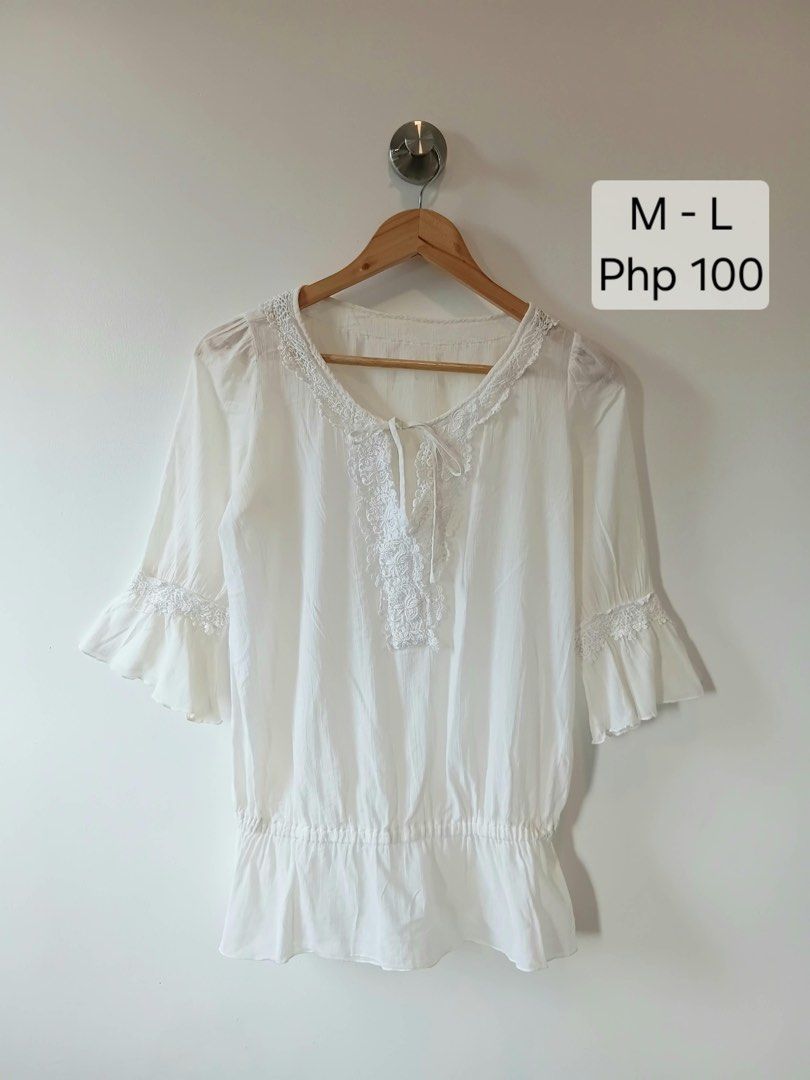 White Lace Trimmed Blouse M-L (Category: Blouses) located in Manila. Submitted by wisecat.4a7eea (Listing ID 1464603231, Image 1). Description: - Elegant white blouse with delicate lace details. - Lace accents around the neckline and sleeves. - Flared three-quarter sleeves with elasticated cuffs. - Adjustable tie detail at the front neckline. - Made from comfortable and airy fabric. - Ideal for a chic casual look..