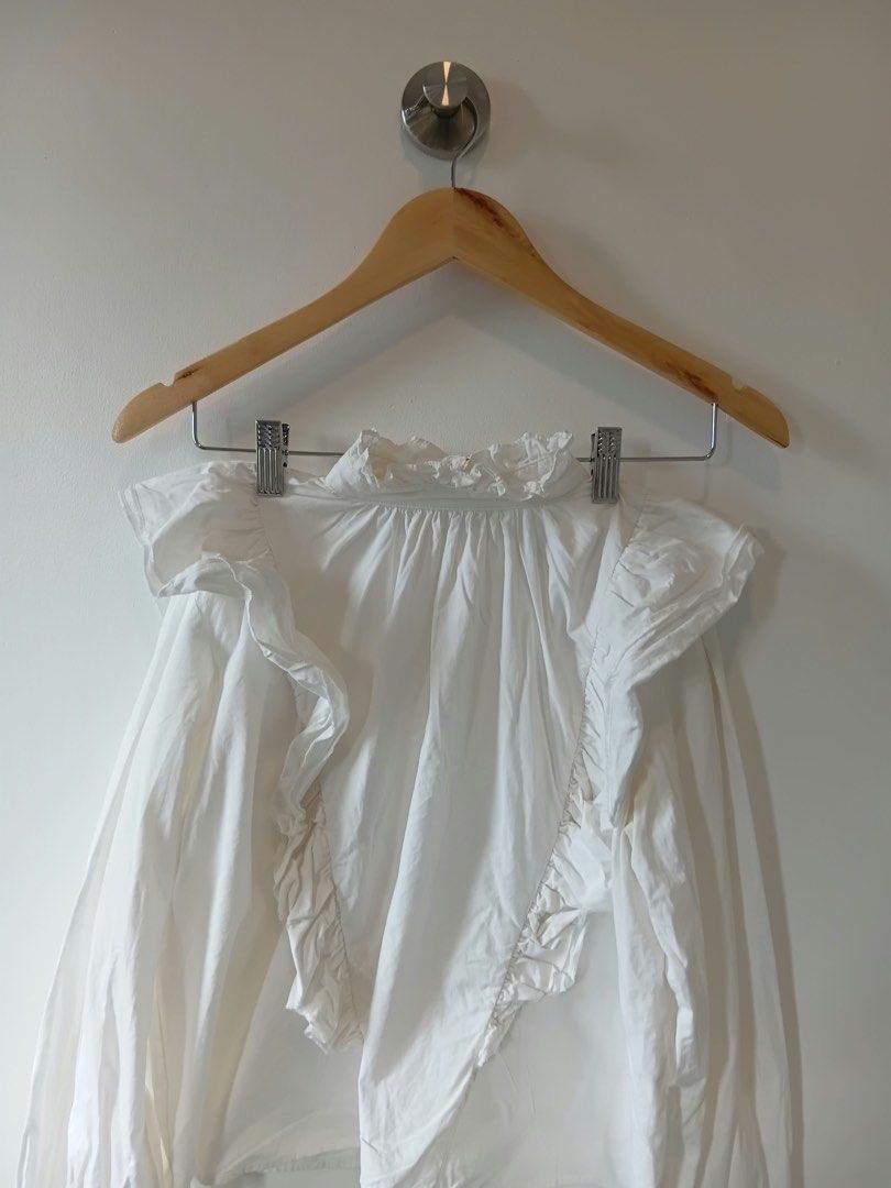 White Ruffle Off-Shoulder Blouse S-M (Category: Blouses) located in Manila. Submitted by wisecat.4a7eea (Listing ID 1464633909, Image 2). Description: - White off-shoulder blouse - Adorable ruffle details on neckline and front - Long sleeves with buttoned cuffs - Perfect for dressing up or down - Fits size Small to Medium (S-M).