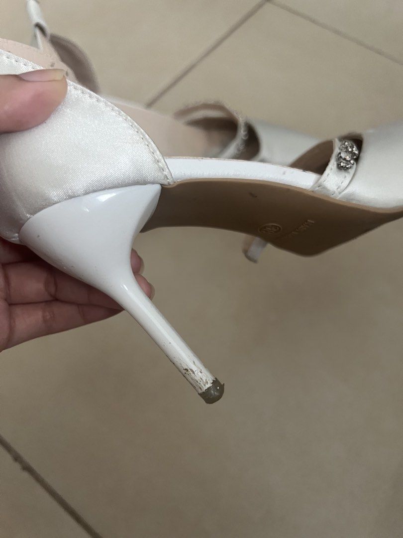 White Satin Heels with Ankle Strap and Rhinestone (Category: Heels) located in Manila. Submitted by doonav (Listing ID 1464597399, Image 3). Description: - size 38 - 3.3 inches - bought for 341 - White satin heels - Pointed toe - Ankle strap with buckle closure - Delicate rhinestone detailing - Ideal for weddings and special occasions - Used for graduation - Has minor flaws and needs cleaning.