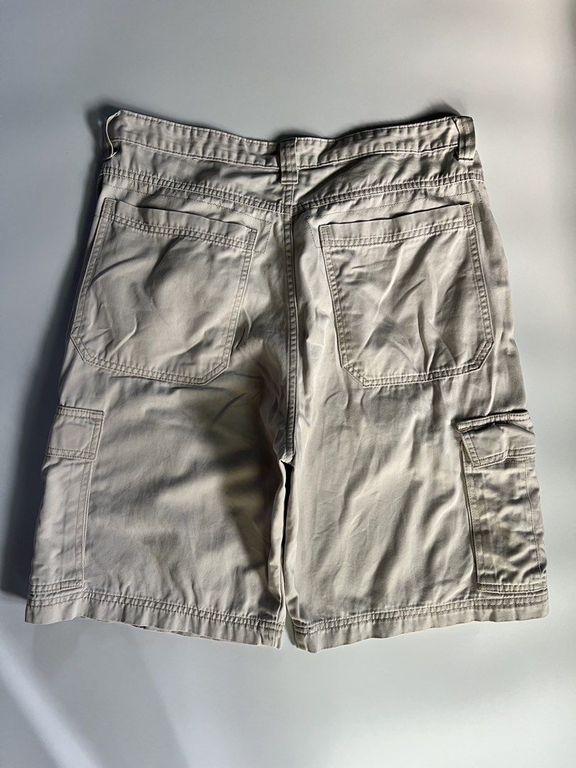 Wrangler Cargo Shorts Beige Men's Utility Pockets (Category: Shorts) located in Baler. Submitted by allthrifted31 (Listing ID 1464732398, Image 2). Description: - Brand: Wrangler - Color: Beige - Style: Cargo shorts with utility pockets, great for streetwear or outdoor activities - Closure: Button waist and zipper fly - Condition: Solid fabric overall, minor fraying near the bottom hem on one side, and the inner waist tag is worn out.