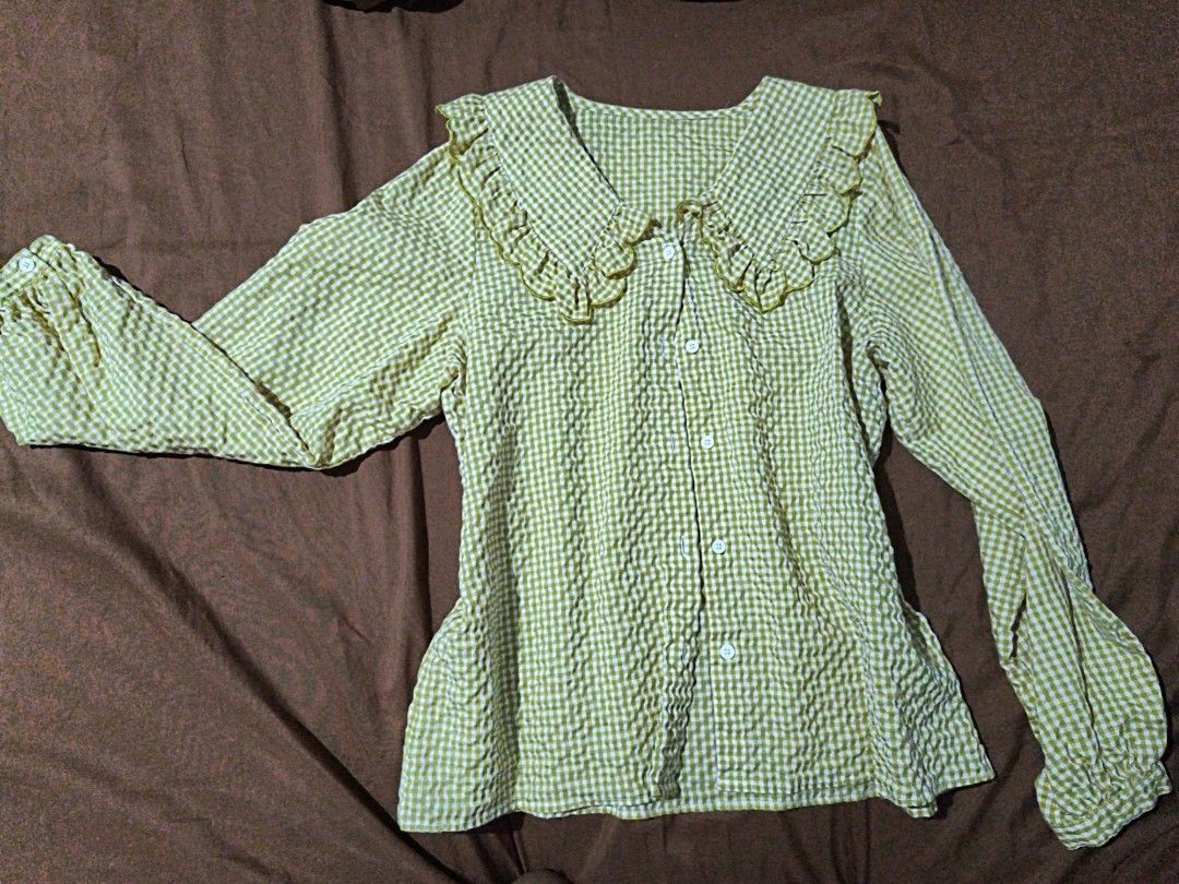 yellow long sleeve blouse (Category: Blouses) located in Manila. Submitted by xoesnup1 (Listing ID 1464741079, Image 1). Description: - Pattern: Yellow and white check seersucker - Details: Big statement collar with ruffled edges and gold piping trim - Closure: Button-down front with white buttons - Sleeves: Long sleeves with gathered elastic cuffs and button closure - Style: Casual, great for layering, skirts, or jeans - Condition: Clean and rea