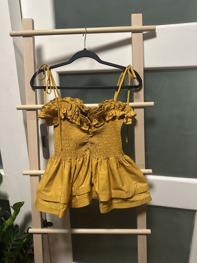 YONG STUDIO Namibia Top in Mustard -30% off (Category: Sleeveless) located in Santa Rosa. Submitted by ms.addtocart (Listing ID 1464744249, Image 2). Description: - Brand: Yong Studio (signature best selling design) - Condition: Brand new with tags - Color: Mustard yellow - Design: Smocked bodice with ruffled sweetheart neckline, signature textured structured layered peplum hem - Straps: Adjustable tie straps - Size: XL but fits Small-Medium-Larg