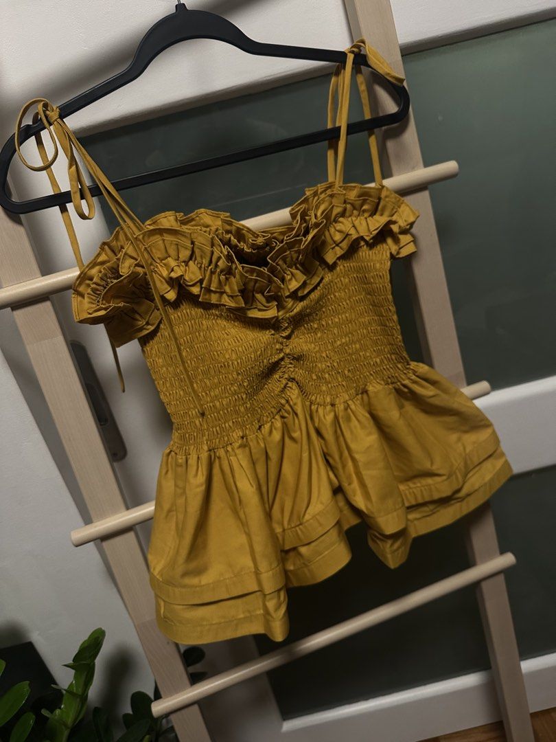 YONG STUDIO Namibia Top in Mustard -30% off (Category: Sleeveless) located in Santa Rosa. Submitted by ms.addtocart (Listing ID 1464744249, Image 3). Description: - Brand: Yong Studio (signature best selling design) - Condition: Brand new with tags - Color: Mustard yellow - Design: Smocked bodice with ruffled sweetheart neckline, signature textured structured layered peplum hem - Straps: Adjustable tie straps - Size: XL but fits Small-Medium-Larg