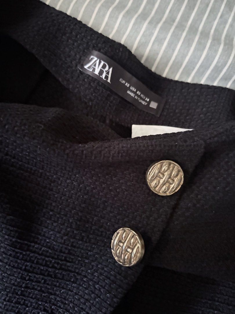 ZARA Black Textured Skort with Gold Buttons (Category: Skirts) located in Consolacion. Submitted by pitang17 (Listing ID 1464598926, Image 3). Description: - Zara black skort - Size XS, fits to 25-26 - Not faded, no issues - Textured fabric - Two decorative gold buttons at the front - Wrap-style front - Made in Turkey - Perfect for dressing up or down Last price posted Delivery fee to be shouldered by the buyer.