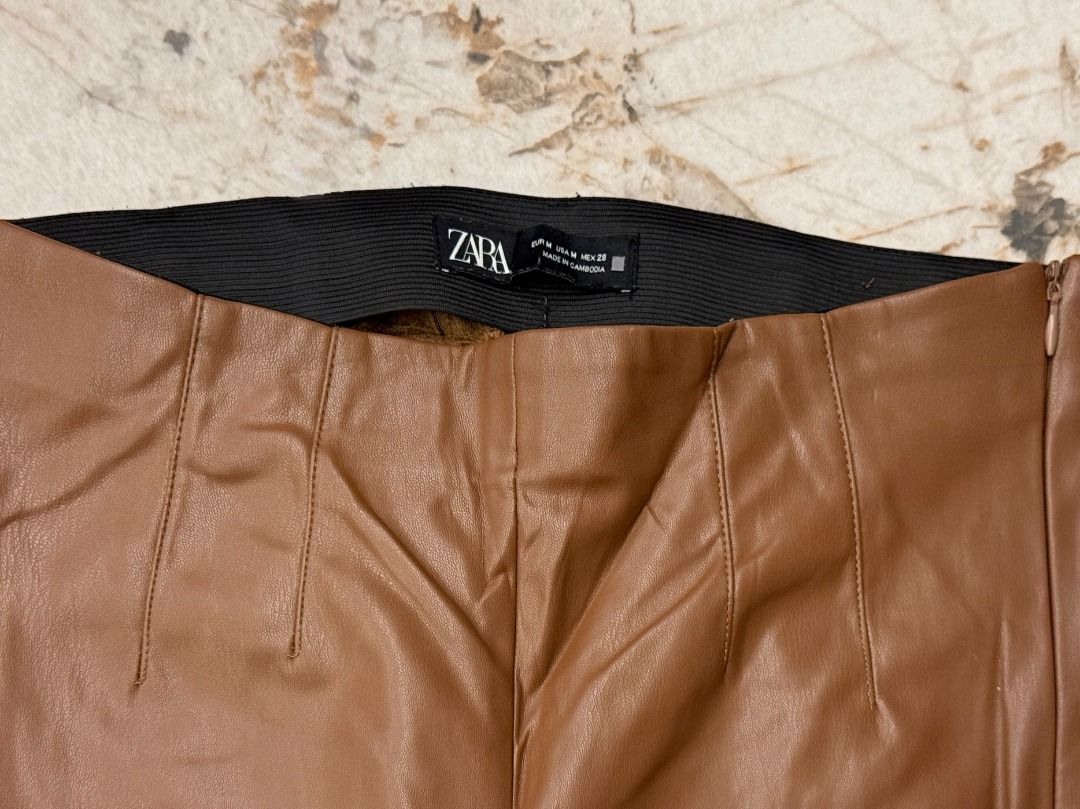 Zara Brown Faux Leather Pants - Medium (Category: Other Bottoms) located in Makati City. Submitted by fpled (Listing ID 1464714232, Image 2). Description: ✨ AUTHENTIC ZARA COATED FAUX LEATHER STRETCH TROUSERS ✨ (Medium • Fits 27”–29” Waist • Rich Cognac / Camel Tan • Soft Interior Lining) Zara high-waisted faux leather pants in brown! Features front seam paneling, a hidden side zipper, and an elasticated interior waistband. Coated stretch fabric 