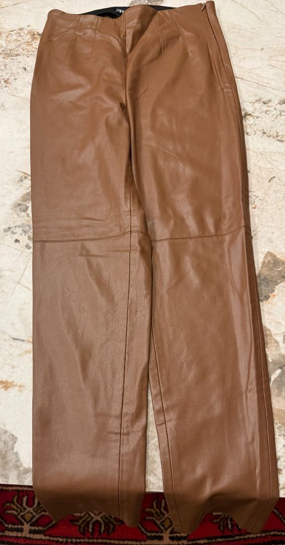 Zara Brown Faux Leather Pants - Medium (Category: Other Bottoms) located in Makati City. Submitted by fpled (Listing ID 1464714232, Image 1). Description: ✨ AUTHENTIC ZARA COATED FAUX LEATHER STRETCH TROUSERS ✨ (Medium • Fits 27”–29” Waist • Rich Cognac / Camel Tan • Soft Interior Lining) Zara high-waisted faux leather pants in brown! Features front seam paneling, a hidden side zipper, and an elasticated interior waistband. Coated stretch fabric 