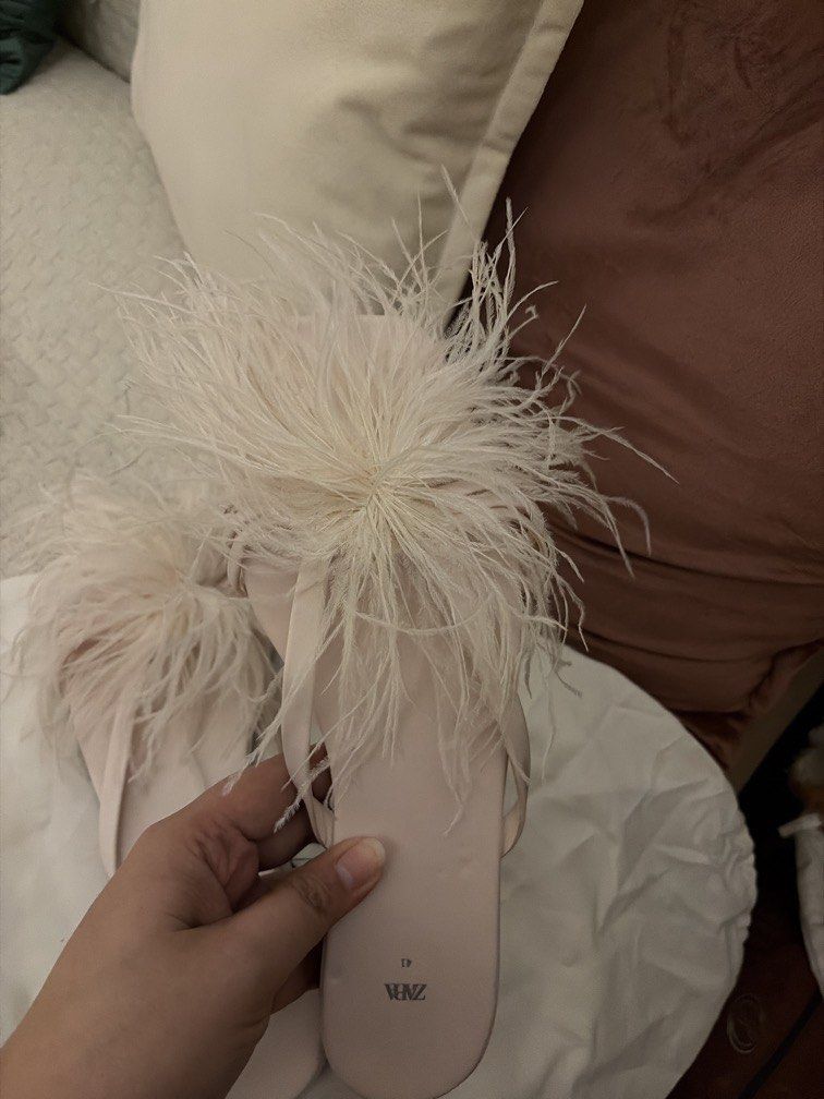 Zara Feather Sandals Pink Size 41 (Category: Flats & Sandals) located in Manila. Submitted by cheska.closet18 (Listing ID 1464734420, Image 2). Description: - Brand: Zara - Style: Feather sandals / slip-on flats - Color: Pale pink - Size: 41 - Details: Soft flat sole, strap design, and a big fluffy feather pom-pom - Inclusions: Original Zara dust bag (note: faint marks on the fabric) - Perfect for: Parties, dinners, or elevating a simple everyday
