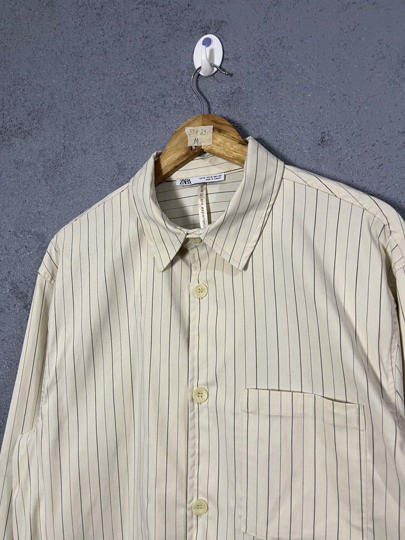 Zara Striped Long Sleeve Button-Up Shirt (Category: Longsleeves) located in Famy. Submitted by basicthrifted (Listing ID 1464702011, Image 3). Description: - Brand: Zara - Style: Striped button-up shirt with chest pocket and classic collar - Color: Beige with dark vertical lines - Size: Medium (Regular Fit) - Origin: Made in Turkey - Condition: Clean piece overall, great for casual or smart-casual wear.