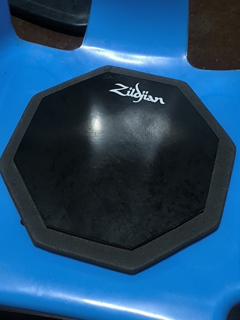 Zildjian Practice Pad Drum Pad (Category: Musical Instruments) located in Muntinlupa City. Submitted by narymadine_ (Listing ID 1464705435, Image 1). Description: - Authentic Zildjian practice pad with octagonal design - Durable rubber playing surface for a realistic rebound - Non-slip foam backing keeps the pad secure during sessions - Excellent tool for building stick control and rudiments quietly at home - Condition: Shows normal signs of use,
