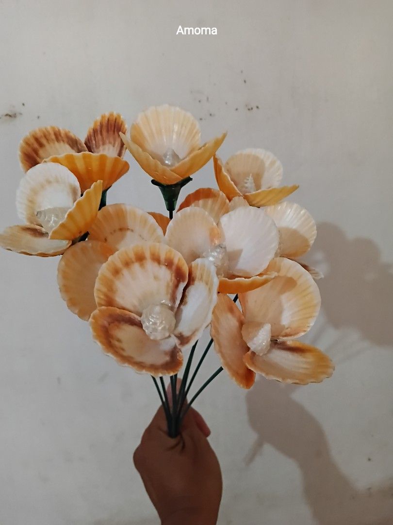 10pcs Handmade seashell flower decor with stems (Category: Flowers & Bouquets) located in Taguig. Submitted by amomaenterprise (Listing ID 1464812454, Image 2). Description: - Handcrafted decorative seashell flowers featuring real seashells shaped like flowers - Made with vibrant orange and white scallop shells with cute spiral shell centers - Set on green artificial stems for a realistic floral look - Lightweight and eye-catching design - Perfec