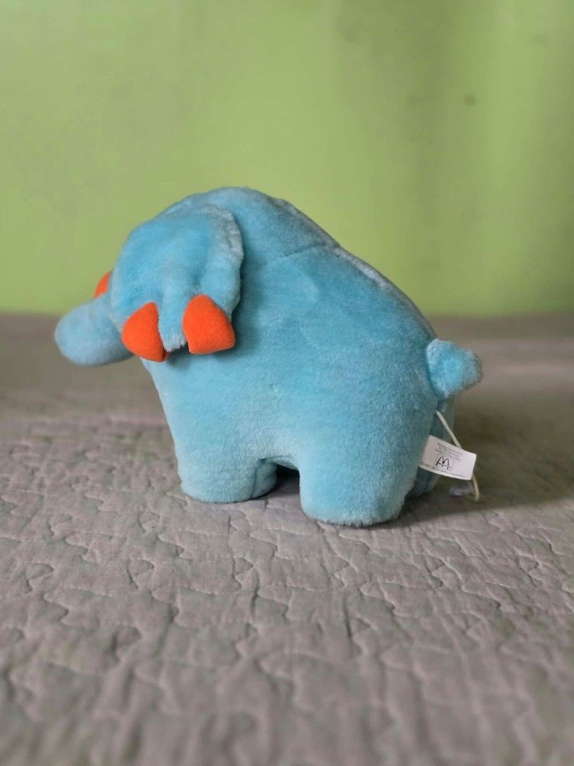 2001 McDonald's Blue Elephant Plush Toy (Category: Plushies & Soft Toys) located in Baguio. Submitted by je_ver_lyn16 (Listing ID 1464846401, Image 1). Description: - Vintage 2001 McDonald's promotional plush toy - Character: Blue elephant with bright orange details on ears and trunk - Size: Approximately 6 inches tall - Material: Soft fabric exterior - Condition: Original tush tag intact with washing instructions and logo - Perfect for toy colle