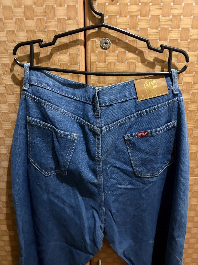 919 Jeans Blue Denim Pants (Category: Jeans) located in Pangil. Submitted by chel_anne (Listing ID 1464842654, Image 3). Description: - Brand/Model: 919 Jeans - Wash: Medium wash denim - Fit: Straight leg, versatile casual wear - Details: Classic five-pocket design with contrast stitching - Waistband: Button closure with belt loops - Branding: Brown leather patch on the back and a small red tag on the pocket flap.