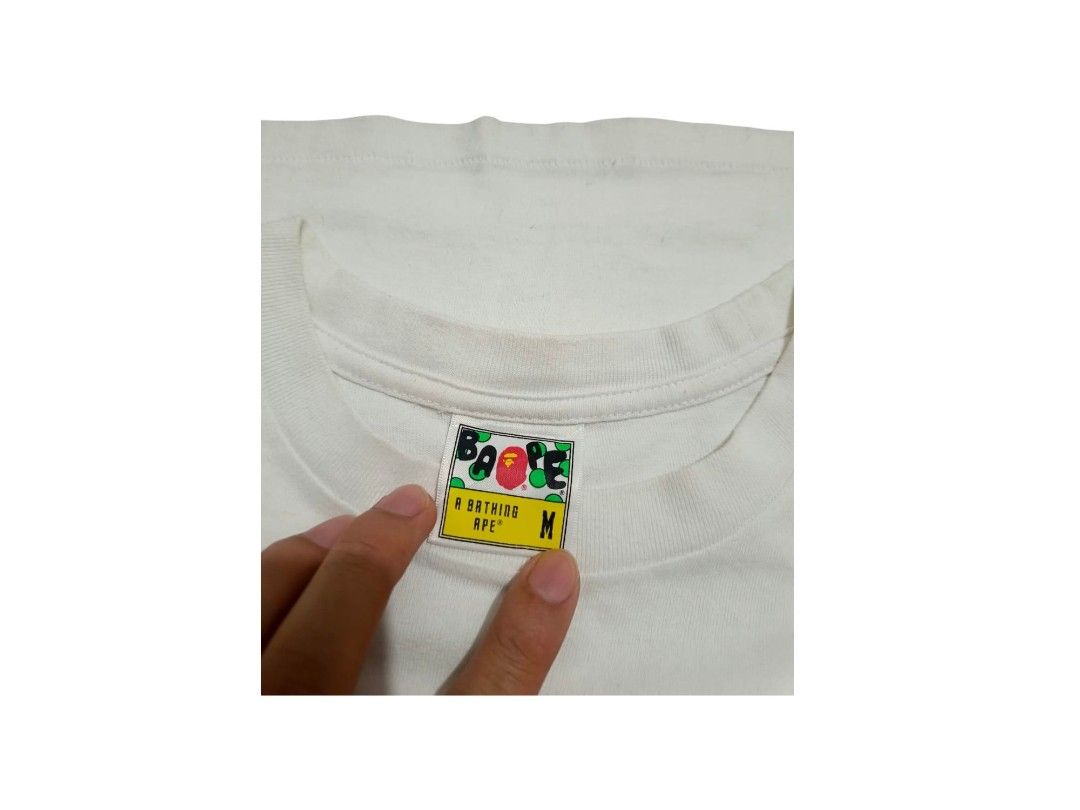 A Bathing Ape Baby Milo Grid Camo (Category: Tshirts & Polo Shirts ) located in Manila. Submitted by southstreethub.ph (Listing ID 1464896862, Image 3). Description: - A Bathing Ape Baby Milo Grid Camo - Size: Medium (tag inside collar) - Dimention: 19.5 Width 27.5 Lenght - Details: Signature ape head logo tag on left sleeve hem, includes woven neck tags - Material: 100% cotton, short sleeves - Condition: Good, with minor yellowing/staining near 