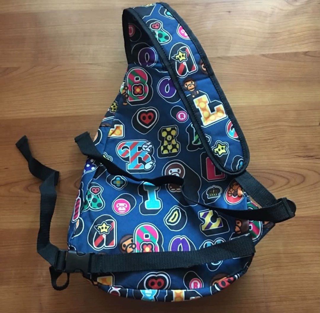 A Bathing Ape BAPE ABC Camo Sling Bag (Category: Sling Bags) located in Rizal. Submitted by timelessfinds89_ (Listing ID 1464918754, Image 2). Description: - Brand: BAPE - Design: Blue multi-color ape head graphic pattern - Material: Durable canvas - Strap: Adjustable black strap with plastic buckle closure - Storage: Diagonal front zipper pocket and compact main compartment for daily essentials - Condition: Clean interior and exterior, no heavy 