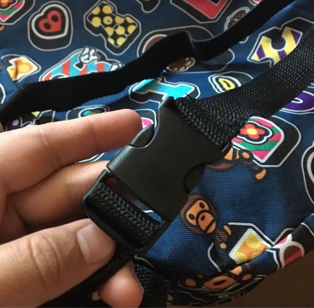 A Bathing Ape BAPE ABC Camo Sling Bag (Category: Sling Bags) located in Rizal. Submitted by timelessfinds89_ (Listing ID 1464918754, Image 3). Description: - Brand: BAPE - Design: Blue multi-color ape head graphic pattern - Material: Durable canvas - Strap: Adjustable black strap with plastic buckle closure - Storage: Diagonal front zipper pocket and compact main compartment for daily essentials - Condition: Clean interior and exterior, no heavy 