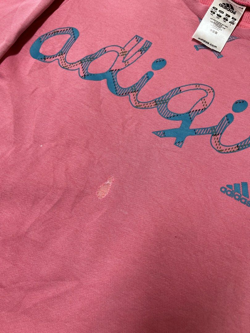 Adidas Adigirl Pink Sweatshirt (Category: Coats, Jackets and Outerwear) located in Cavite. Submitted by bellewii (Listing ID 1464910325, Image 3). Description: - Brand: Adidas - Style: Adigirl Crewneck Sweatshirt - Color: Pink with plaid graphic - Size: Tagged 13-14Y (UK/USA L, 164) - Features: Soft fleece inner lining, iconic blue trefoil logo - Flaws: Noticeable scratch near center front chest and a fade mark near the bottom hem - Perfect for c