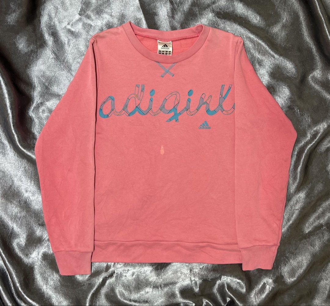 Adidas Adigirl Pink Sweatshirt (Category: Coats, Jackets and Outerwear) located in Cavite. Submitted by bellewii (Listing ID 1464910325, Image 1). Description: - Brand: Adidas - Style: Adigirl Crewneck Sweatshirt - Color: Pink with plaid graphic - Size: Tagged 13-14Y (UK/USA L, 164) - Features: Soft fleece inner lining, iconic blue trefoil logo - Flaws: Noticeable scratch near center front chest and a fade mark near the bottom hem - Perfect for c